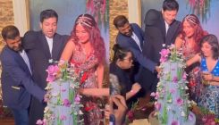 Ali Fazal and Richa Chadha struggle to cut the three-tier wedding cake as guests help