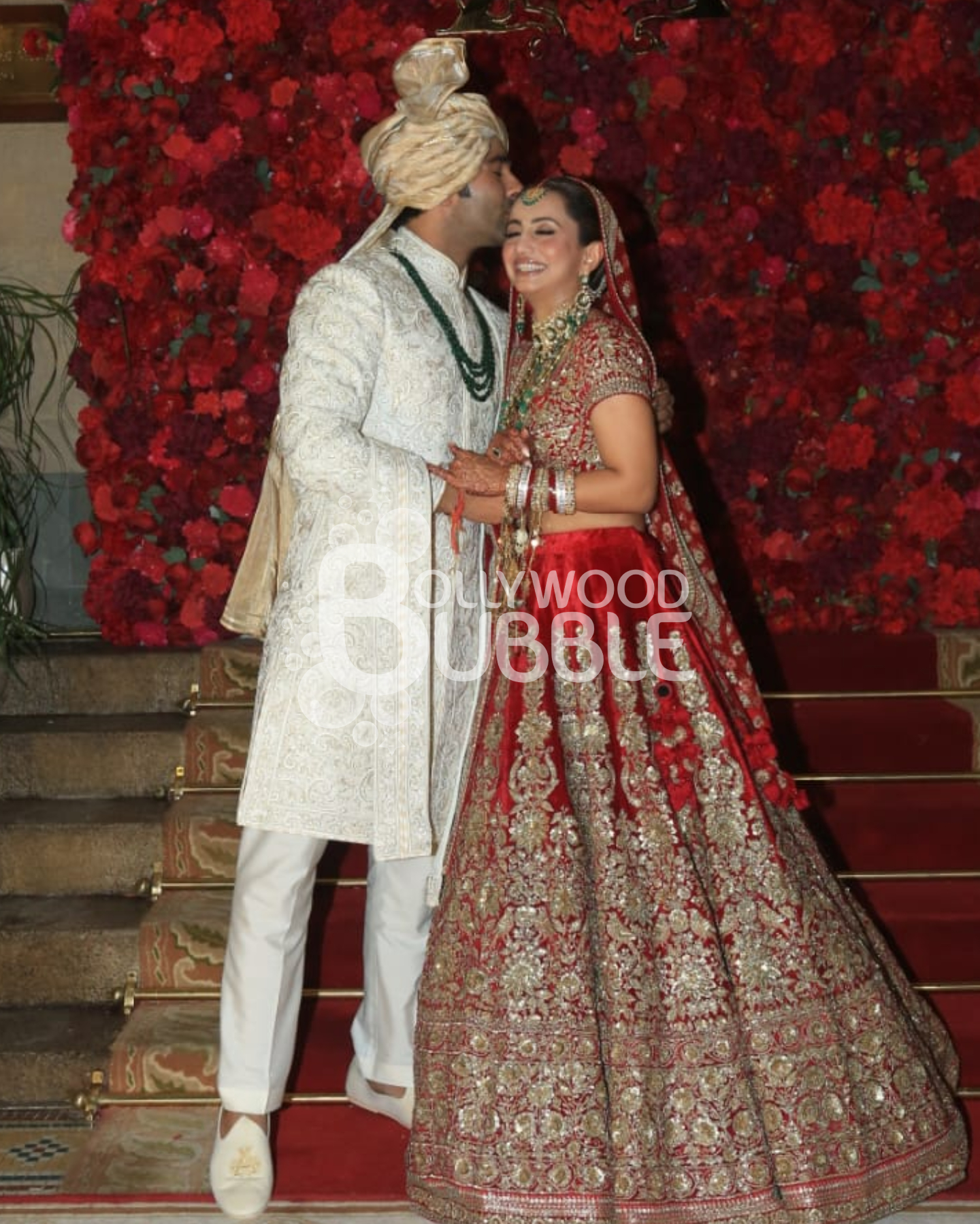 Aadar Jain kisses wife Alekha Advani as they pose for the paps