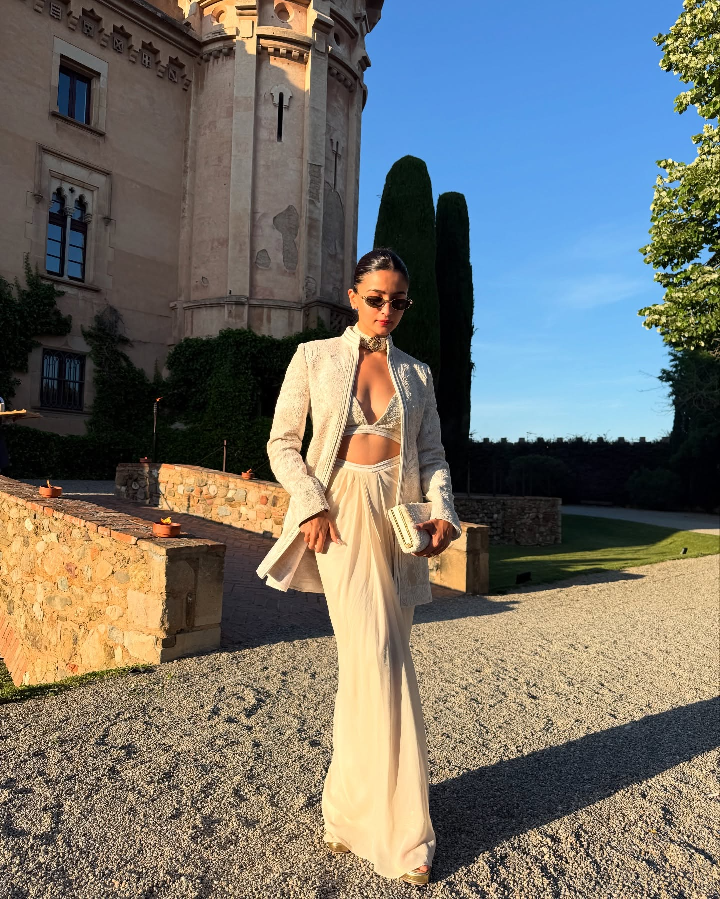 Alia Bhatt in a white embellished bralette, matching blazer, and cream skirt